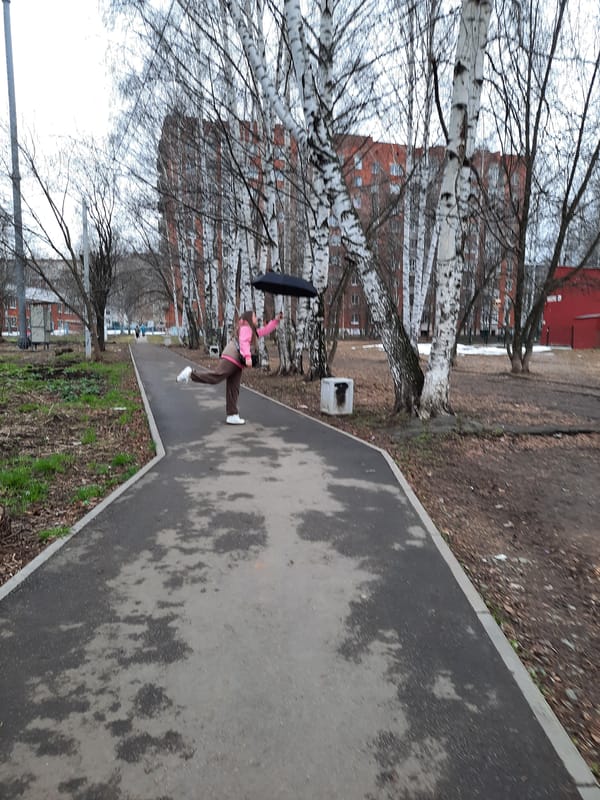 Pedestrians navigate wet sidewalks in Izhevsk during afternoon