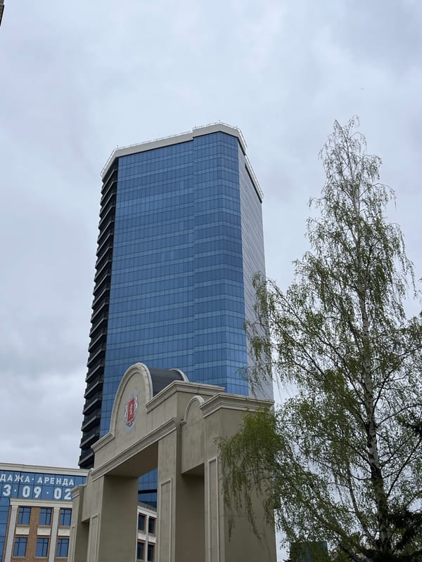 Glass skyscraper observed through trees in Krasnoyarsk, Russia