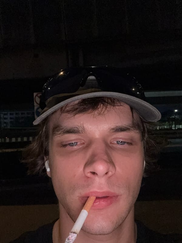 Young man photographed smoking on Bangkok street at night