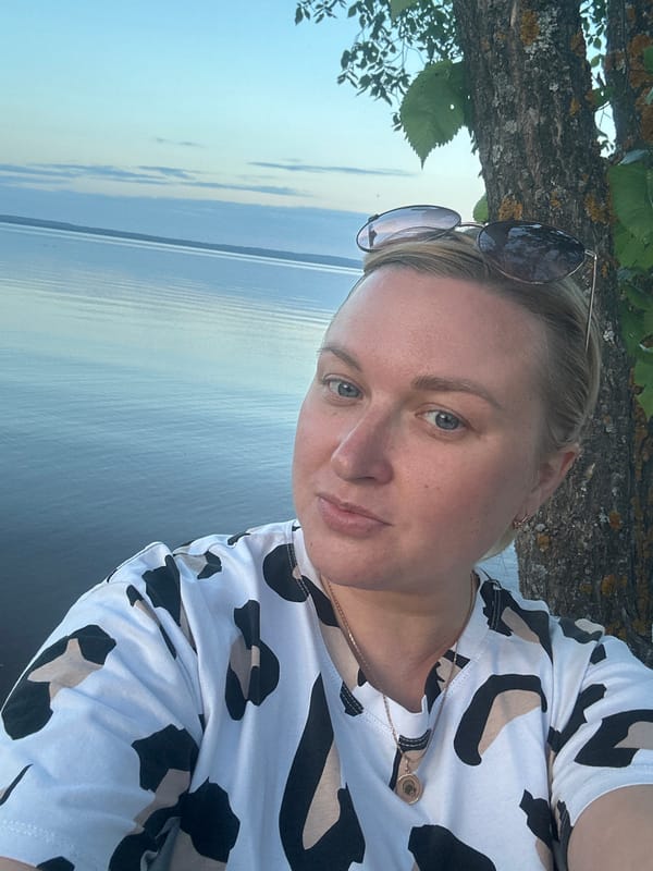 Woman takes evening selfies by water in Noviy Russia