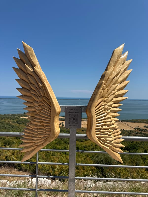 Carved wooden wings at a coastal overlook in Cagnano Varano