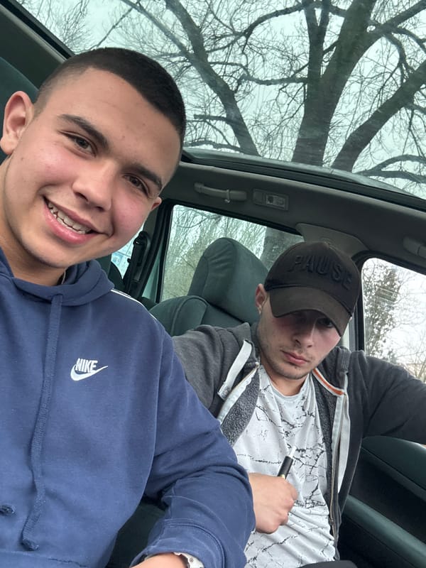 Two men hang out in car in Topoli