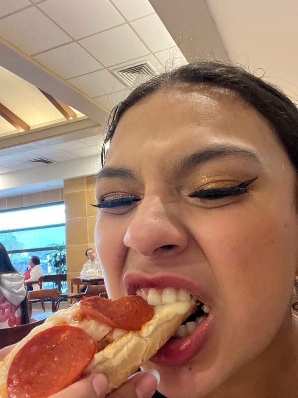 Woman enjoys pizza while enchiladas served at restaurant