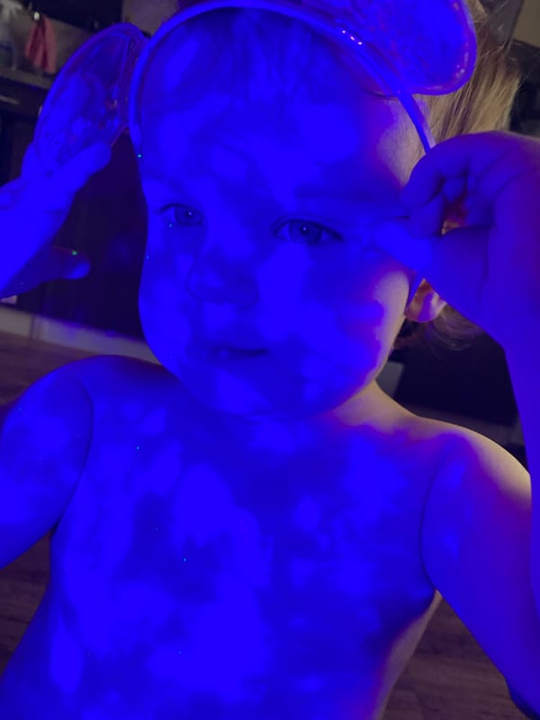Toddler plays with parakeet, colored lights in afternoon session