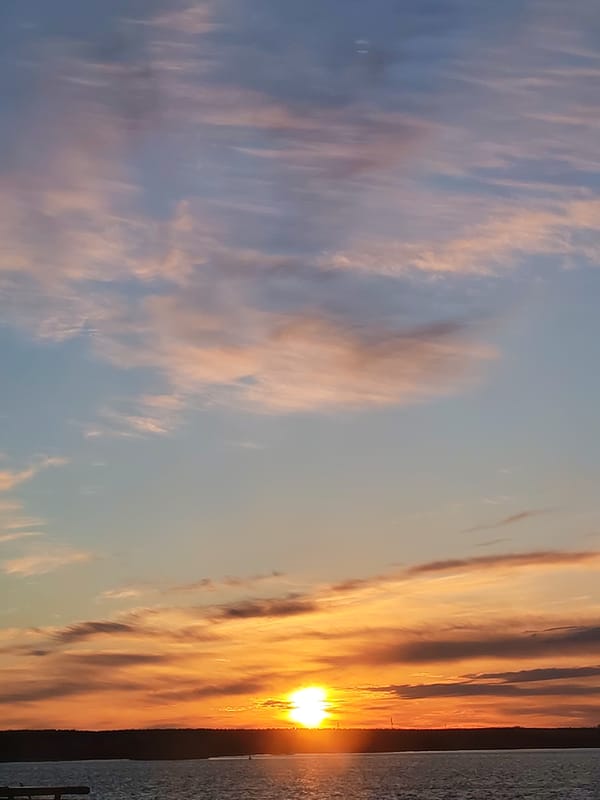 Sunset observed over water in Bol'shie Mkhi, Russia