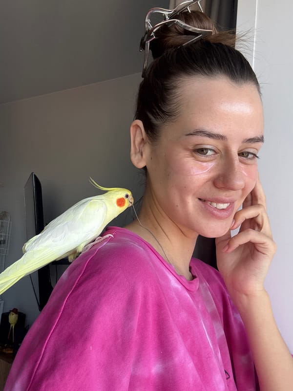 Woman poses with pet cockatiel during breakfast in Krasnoyarsk