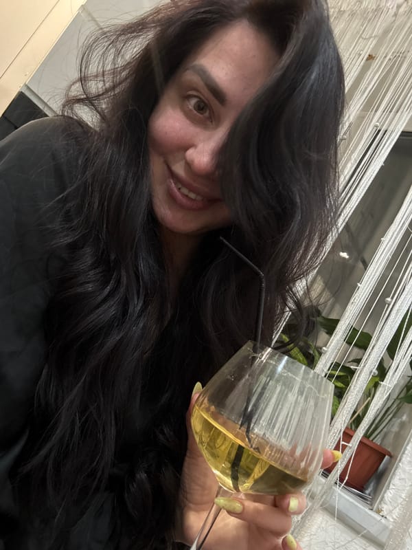 Woman enjoys yellow drink at home with tulips