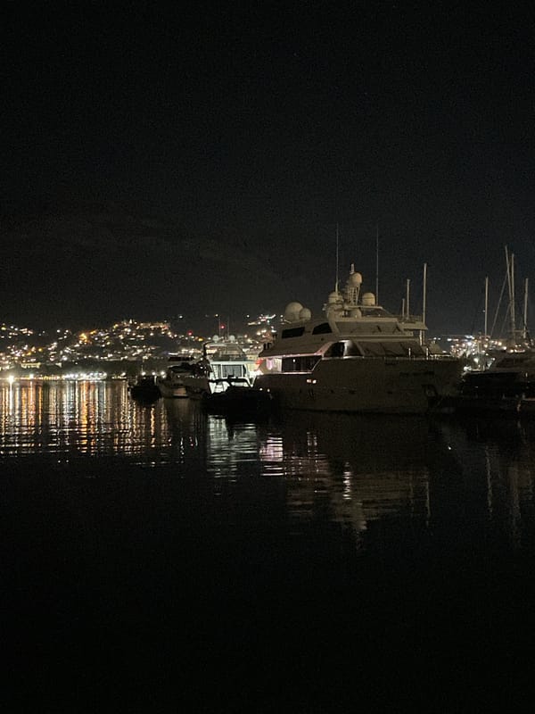 Bar marina at night, boats moored under a crescent moon