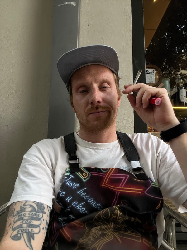 Man smoking cigarette on Tel Aviv street amid mixed architecture