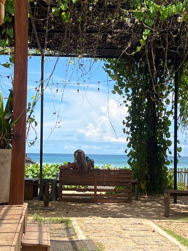Person sits on bench overlooking ocean in Goviyapana, Sri Lanka