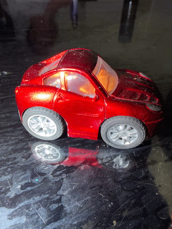 Toy collection display featuring cars, figurines, and candles