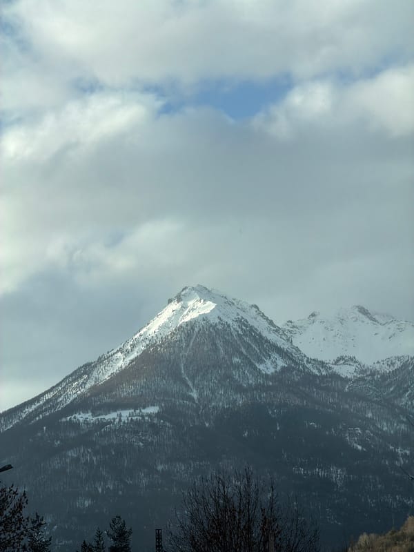 Snow-covered mountain photographed under cloudy skies near Briançon