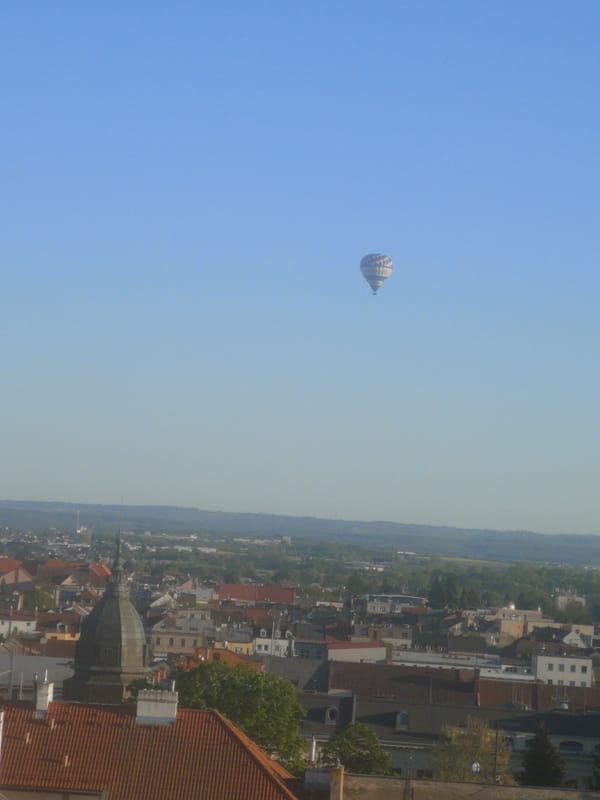 Hot air balloon ascends over Pardubice under clear skies