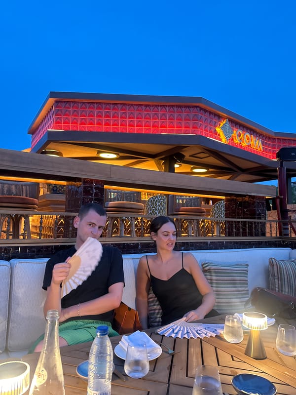 Outdoor dining as dusk falls, drinks in hand.