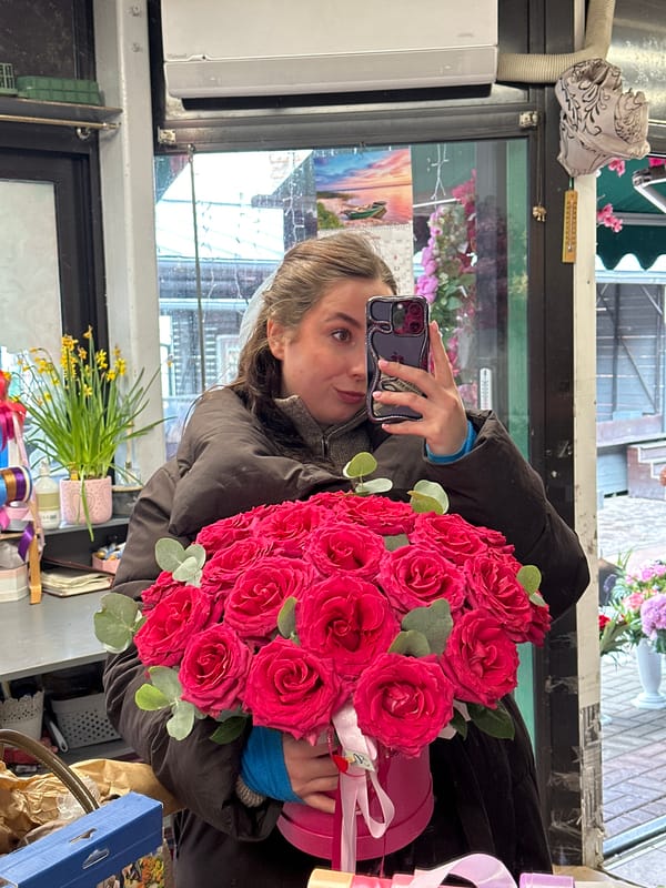 Woman takes selfie with pink roses at Latvian flower shop