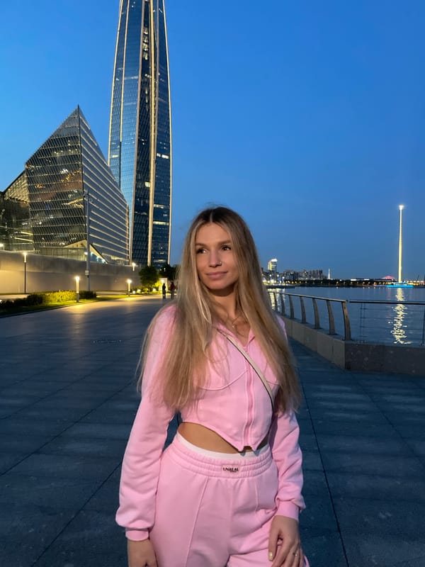 Woman in pink tracksuit spotted at Peterhof waterfront during dusk