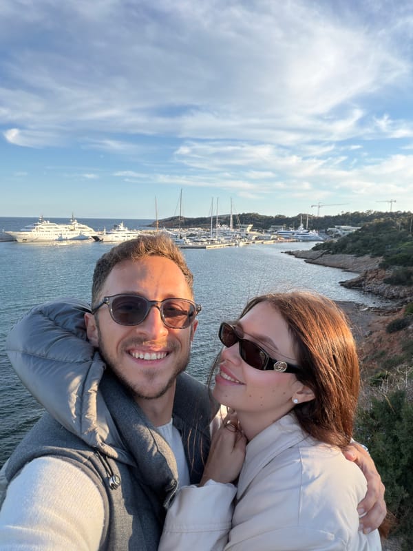 Tourists photograph scenic harbor views in Vouliagmeni, Greece