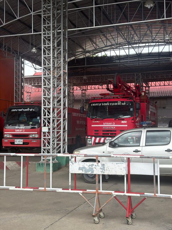 Fire station in Chang Phueak with trucks parked under metal roof