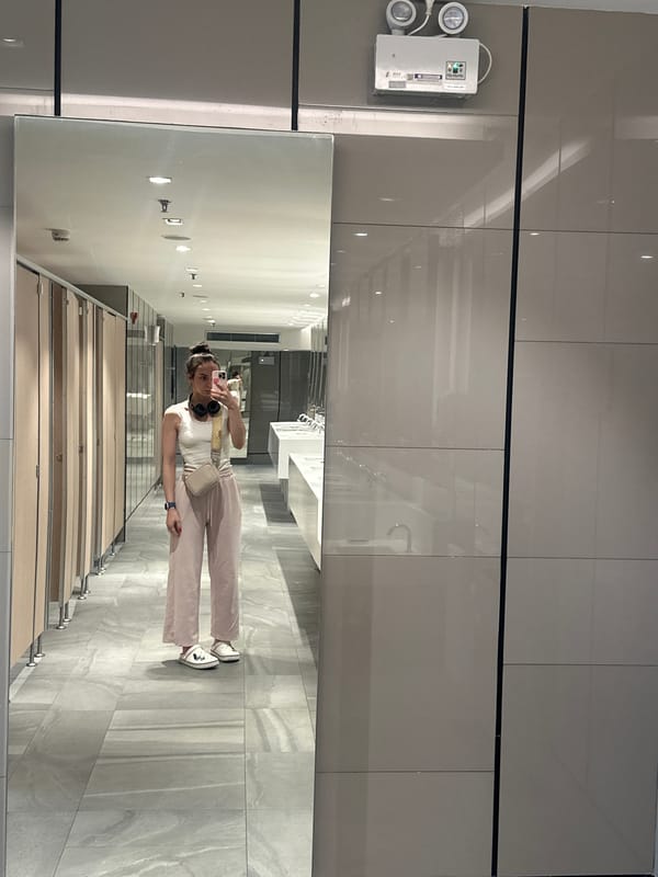 Woman takes selfie in public restroom mirror in Thailand