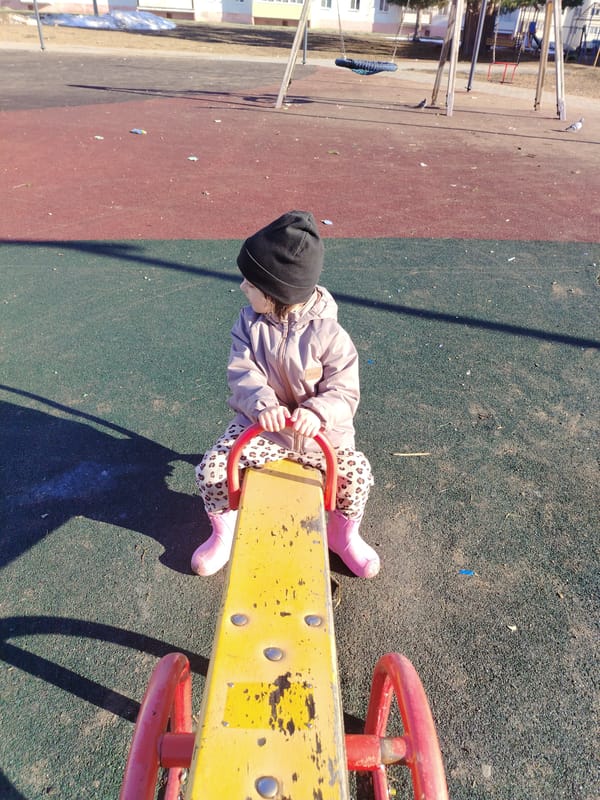 Young child plays on playground equipment in Noviy, Russia