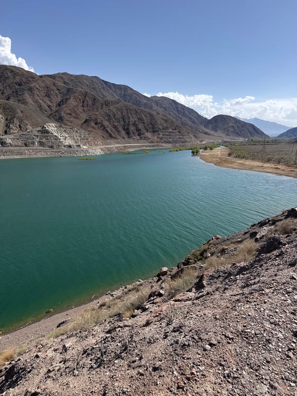 Tourist photographs turquoise mountain lake in Kyrgyzstan