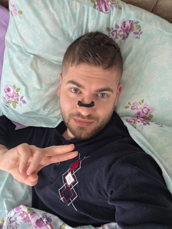 Man photographed in bed wearing patterned sweater in Bulgaria