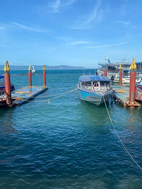 Palace pier documented with boats, Thai maritime insignia visible