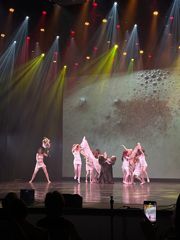 Contemporary dance performance on a dramatically lit Riga stage
