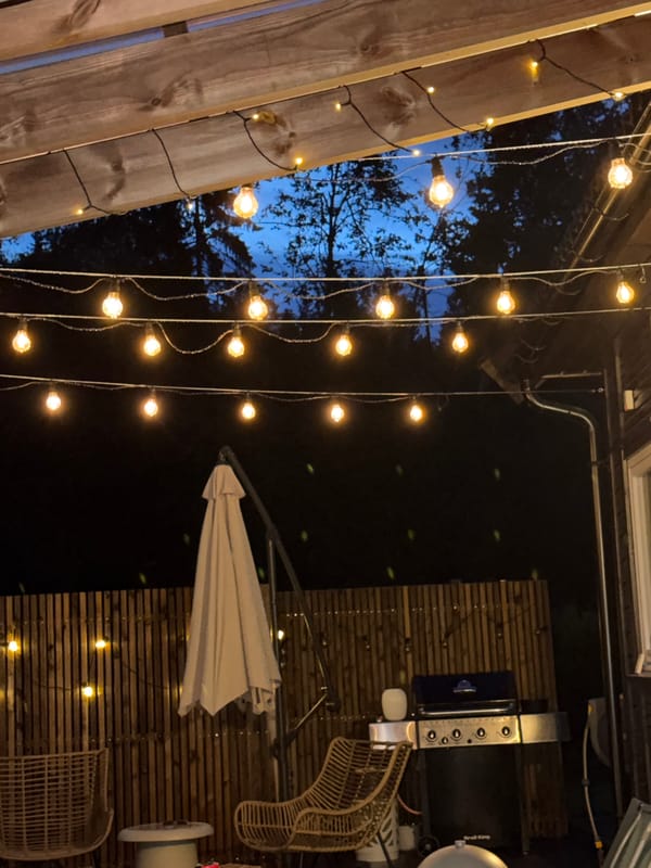 String lights over a Norwegian patio at dusk