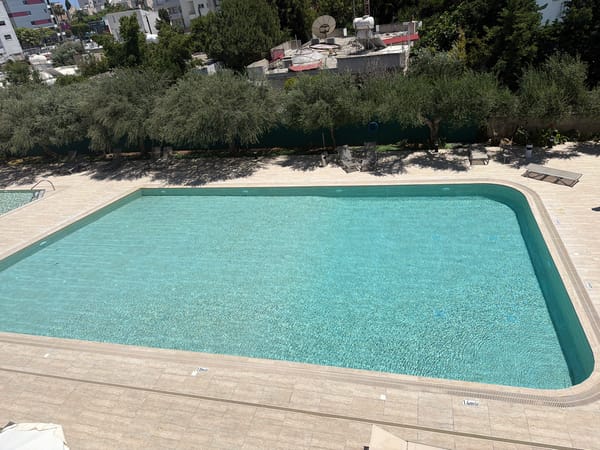 Woman sunbathes poolside at Cyprus recreational facility