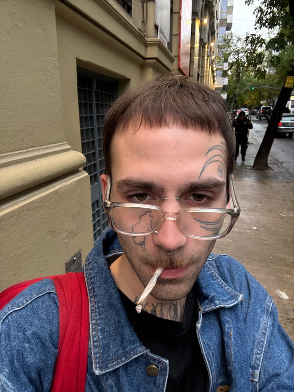 Man with facial tattoos smokes cigar on Buenos Aires sidewalk