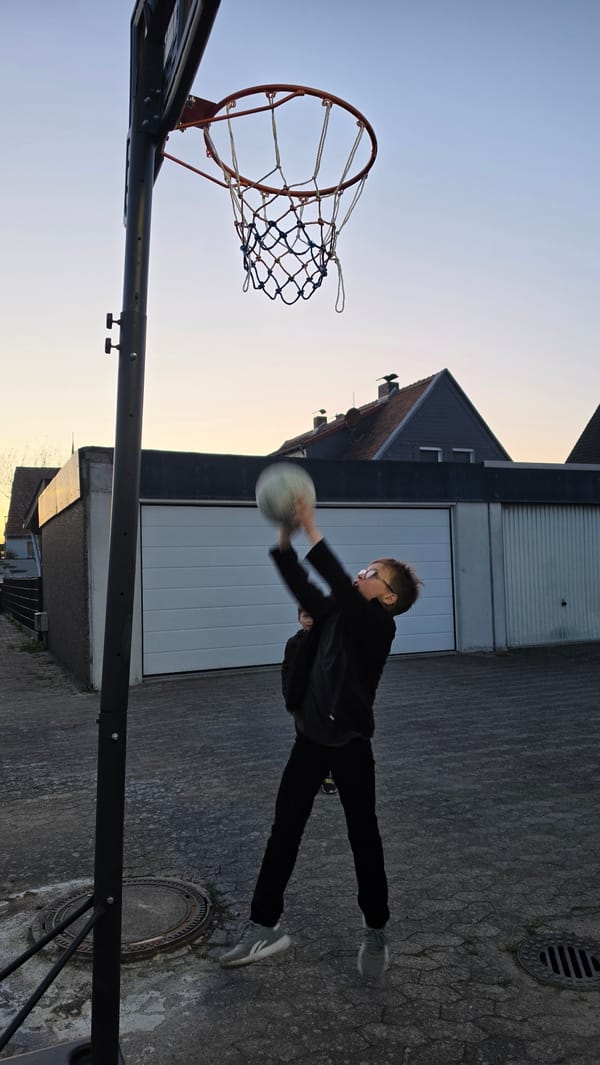 Young basketball player captured mid-shot at Ihringshausen outdoor court