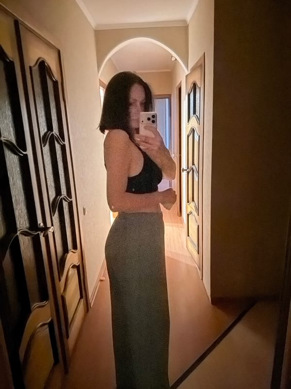 Person takes mirror selfies indoors during evening hours