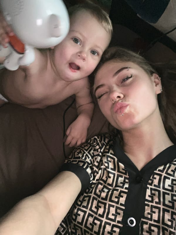 Woman with piercings rests beside baby in Foki, Russia