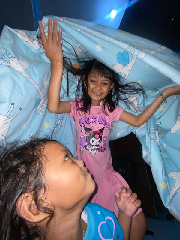 Children play and rest during family time in Gelam
