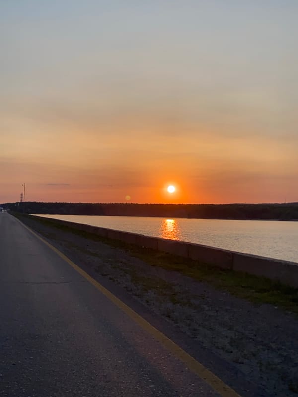 Roadside sunset over calm water, golden hour from multiple angles
