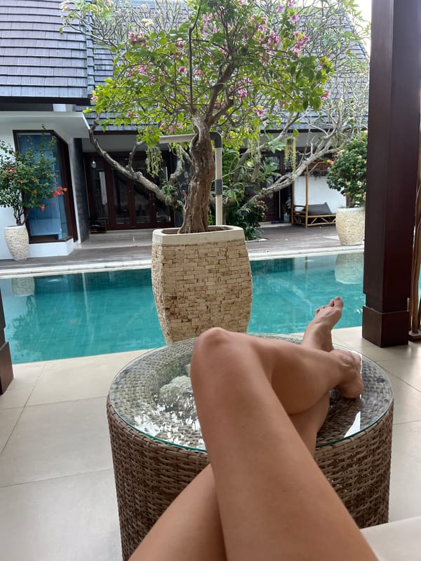 Woman relaxes poolside in North Kuta resort area