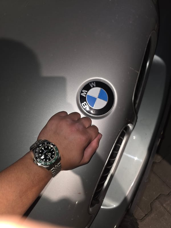 Luxury watch displayed near BMW in nighttime Sevlievo scene