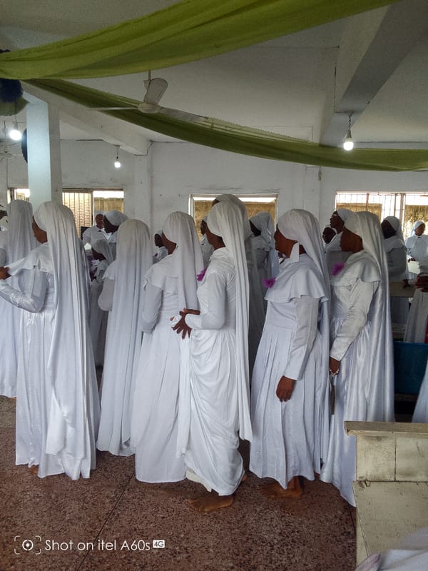 White-robed group gathers indoors for apparent ceremonial activity