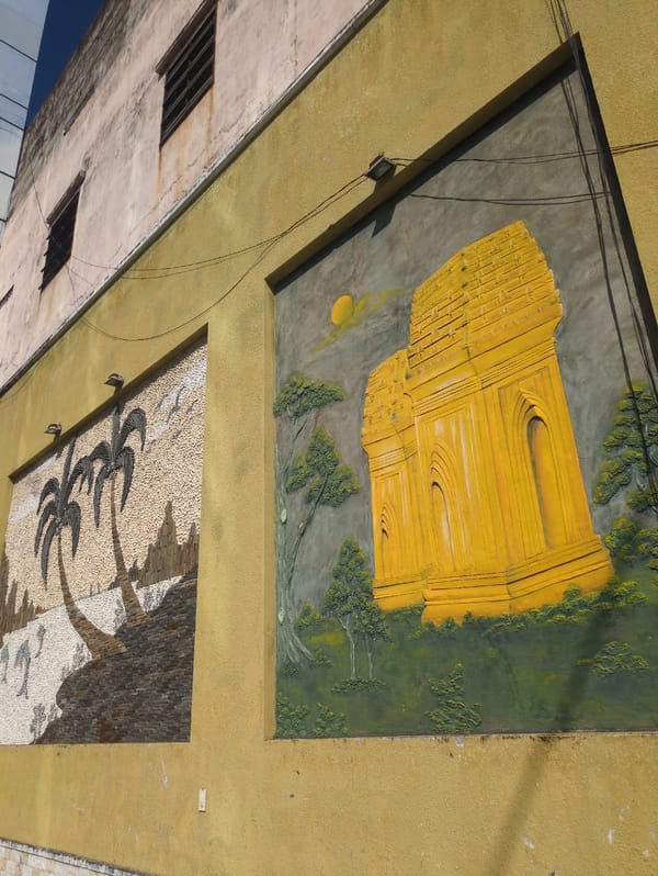 Weathered building with Vietnamese landscape mural observed in Quy Nhon