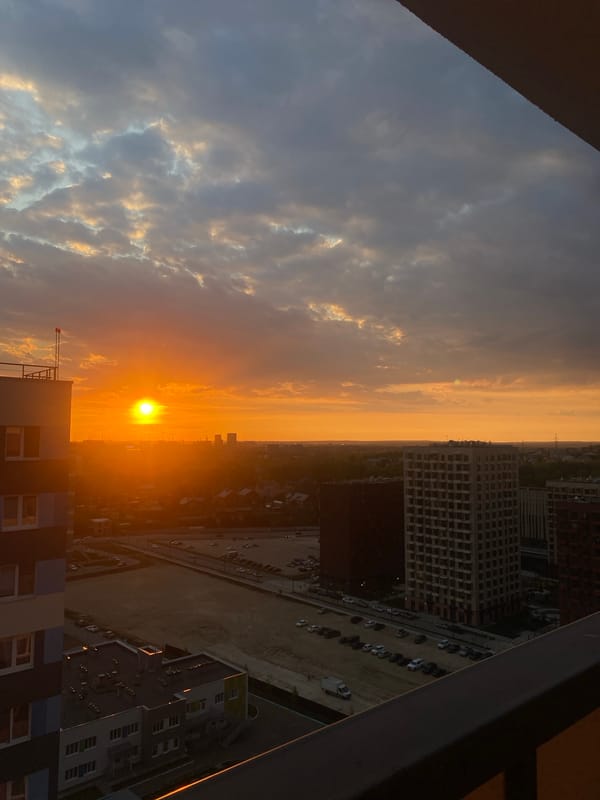 Orange sunset illuminates Russian cityscape with construction sites