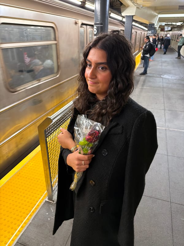 Woman holds flower bouquet on NYC subway platform early morning