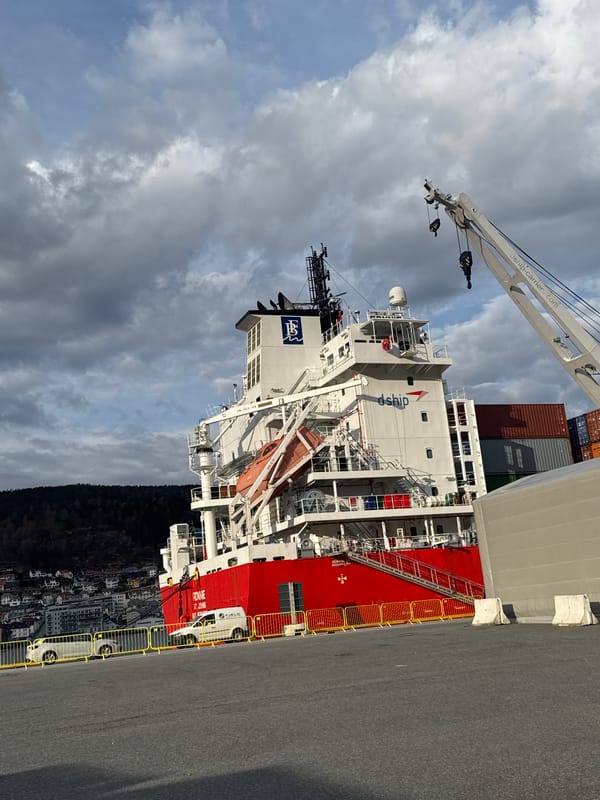 Cargo ship with dship logo docked at Bergen pier