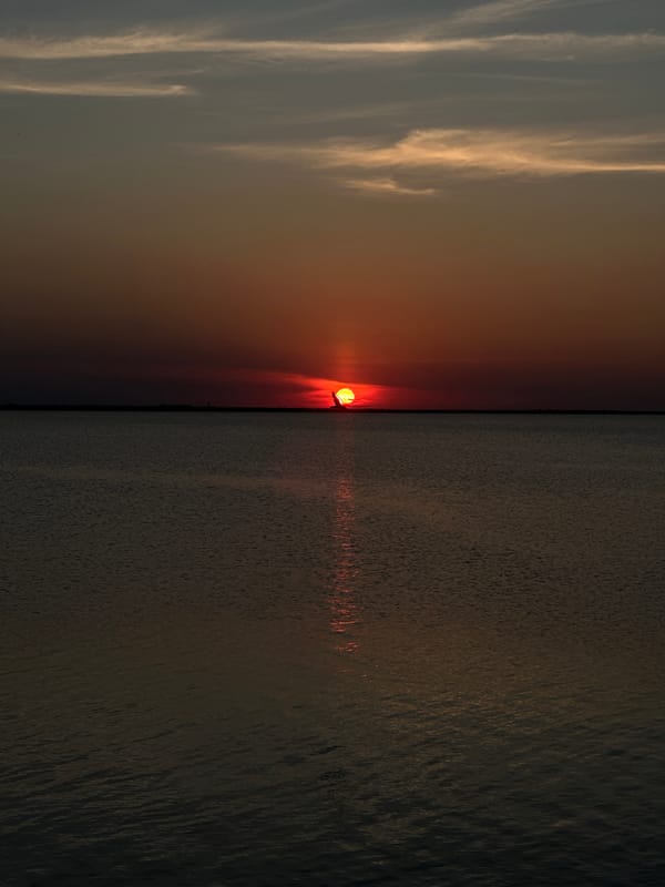 Motorboat on a Kazakh lake at a fiery summer sunset