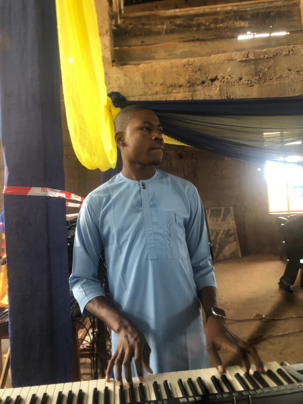 Man plays keyboard in decorated room in Nteje, Nigeria