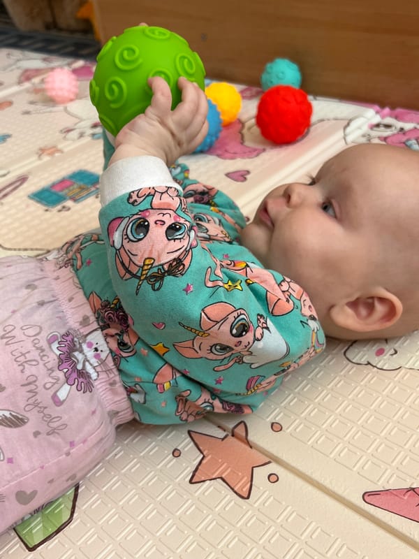 Baby plays on decorated mat in Votkinsk