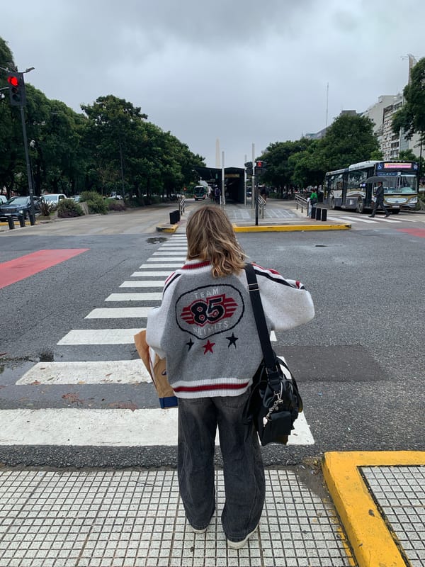 Person crosses street in Buenos Aires wearing striped sweater