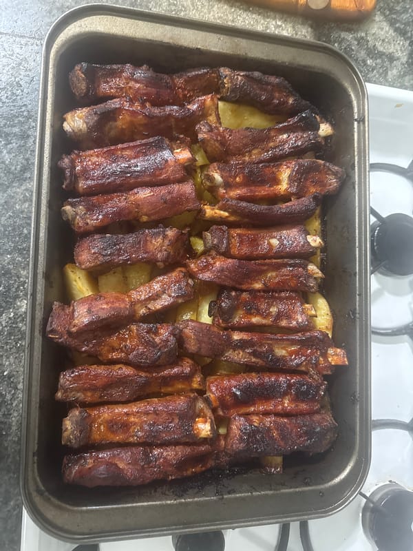 Home-cooked ribs and potatoes prepared in baking tray