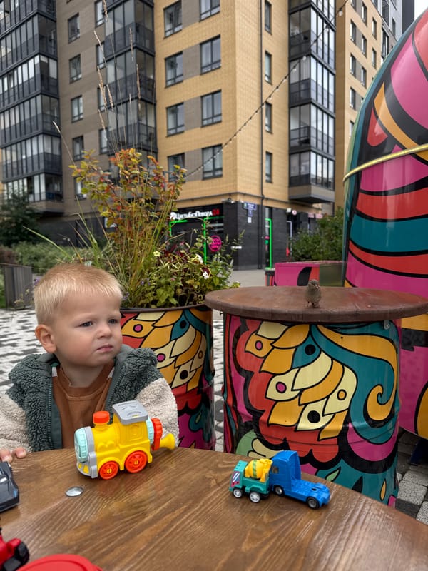 Toddler lunch break at a colorful food truck, sparrows included