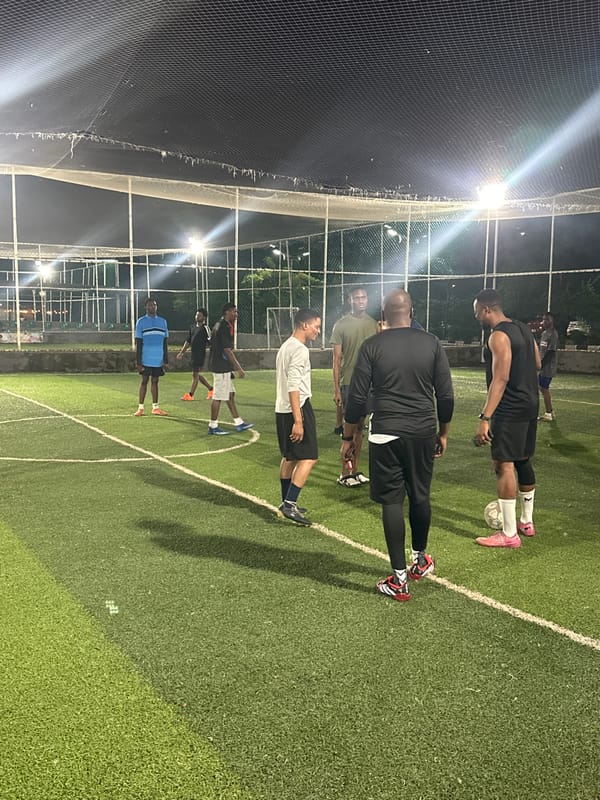 Evening football session on a floodlit astroturf pitch in Abuja